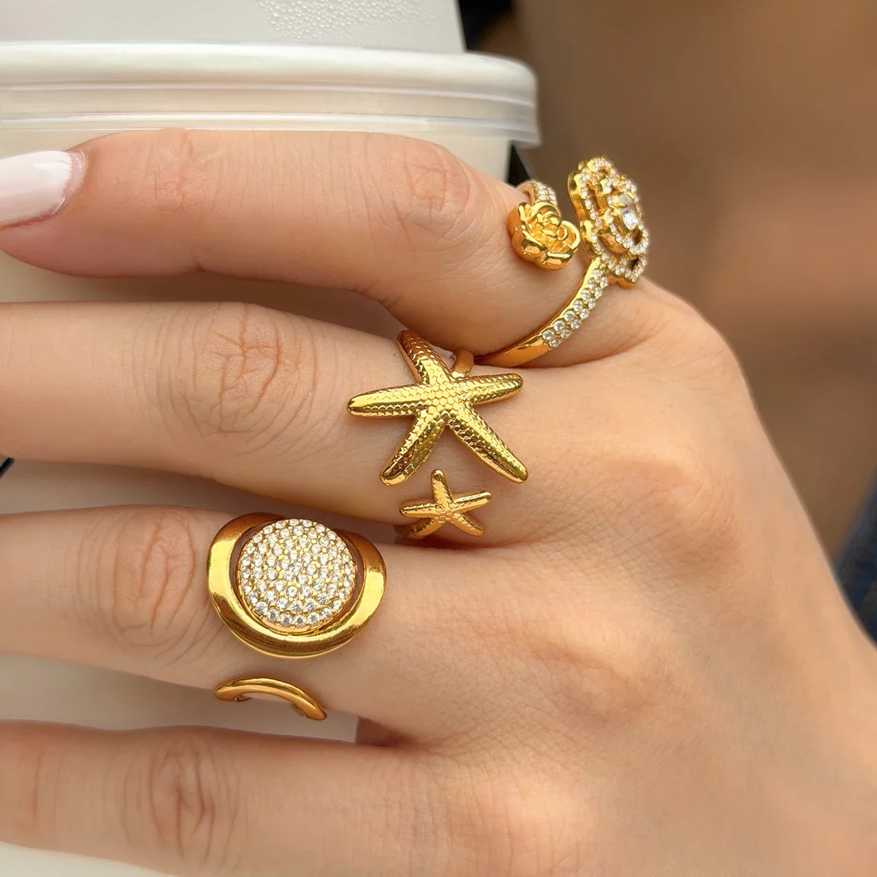Open ringen met bloem, pavé-disc en zeester, Gold PVD productfoto