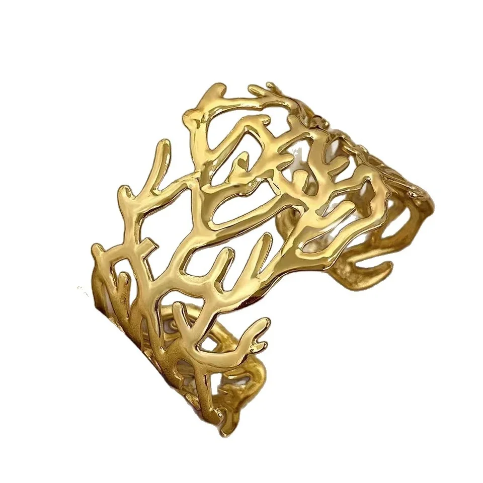 Brazalete rígido con motivo de ramas caladas, acero chapado en oro