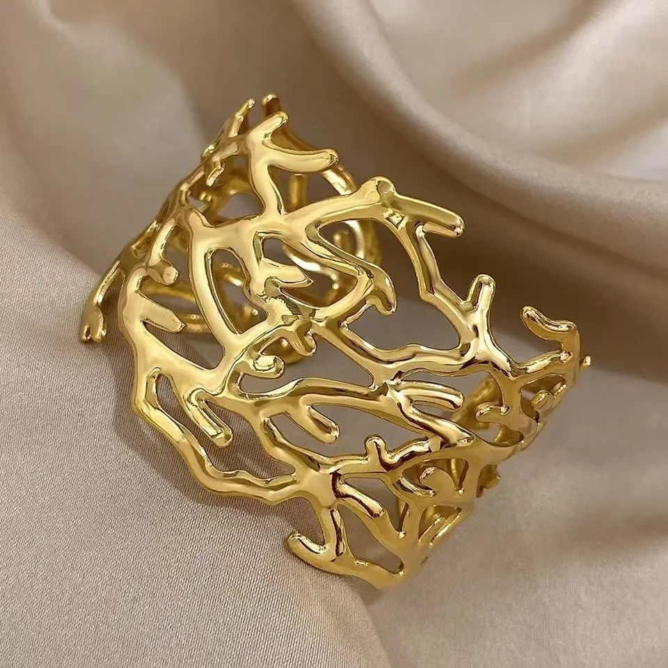 Foto del producto: Brazalete rígido con motivo de ramas caladas, acero chapado en oro