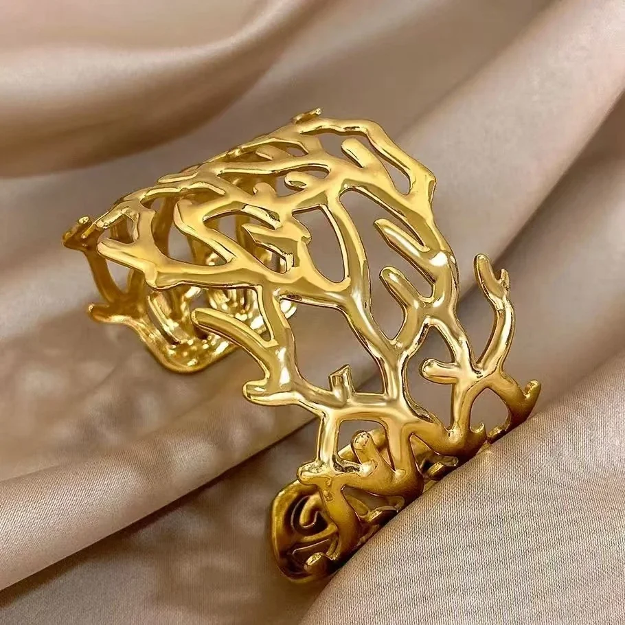 Foto del producto: Brazalete rígido con motivo de ramas caladas, acero chapado en oro