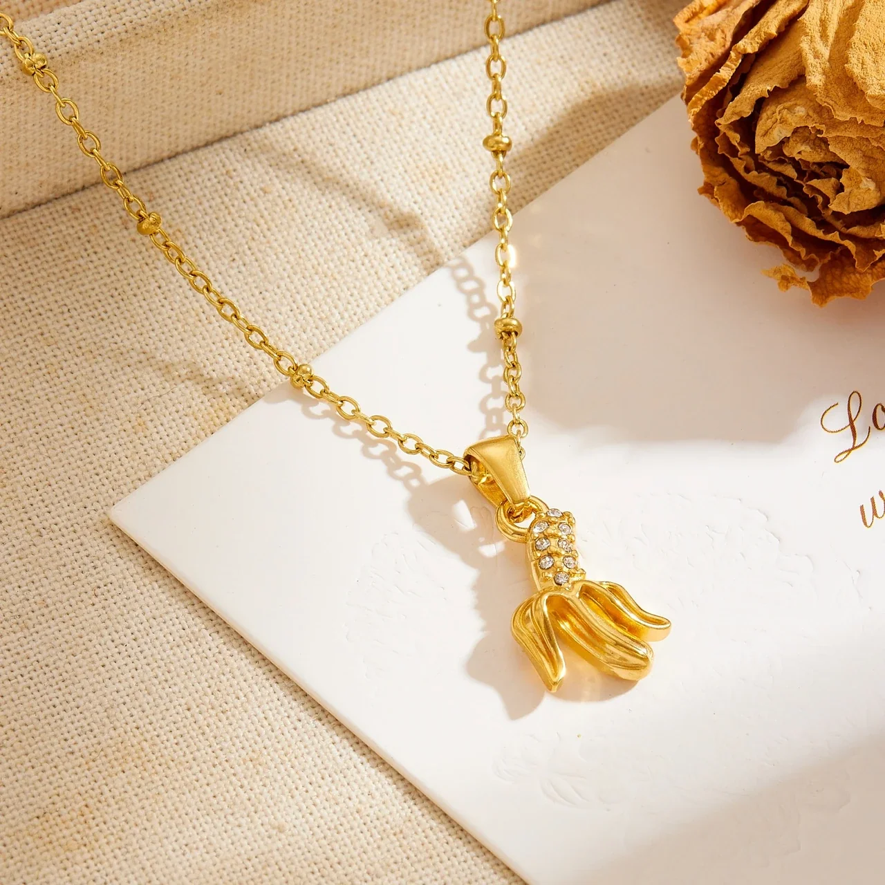 Photo produit : Collier pendentif banane avec chaîne perlée, acier plaqué or