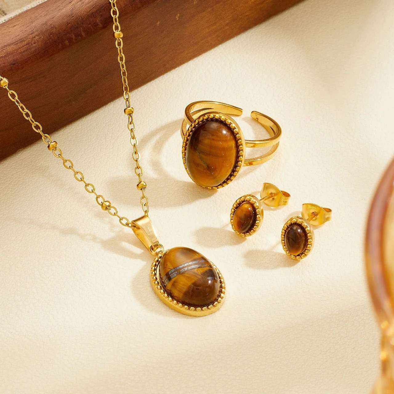 Produktfoto: Schmuckset mit ovalem Cabochon und Perlenrahmen aus vergoldetem Edelstahl