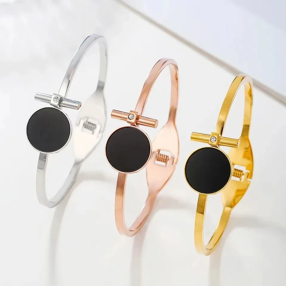 Foto del producto: Brazalete rígido con disco redondo negro y barra, acero chapado en oro