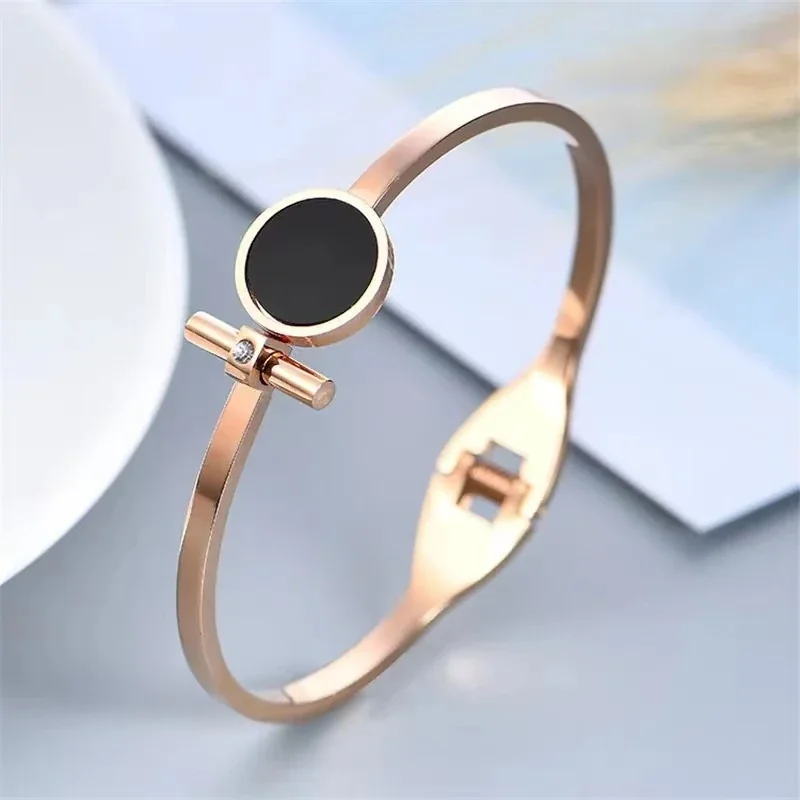 Foto del producto: Brazalete rígido con disco redondo negro y barra, acero chapado en oro