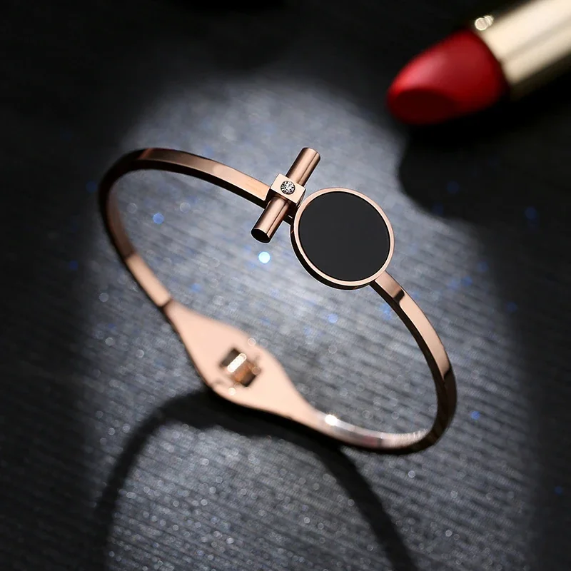 Foto del producto: Brazalete rígido con disco redondo negro y barra, acero chapado en oro