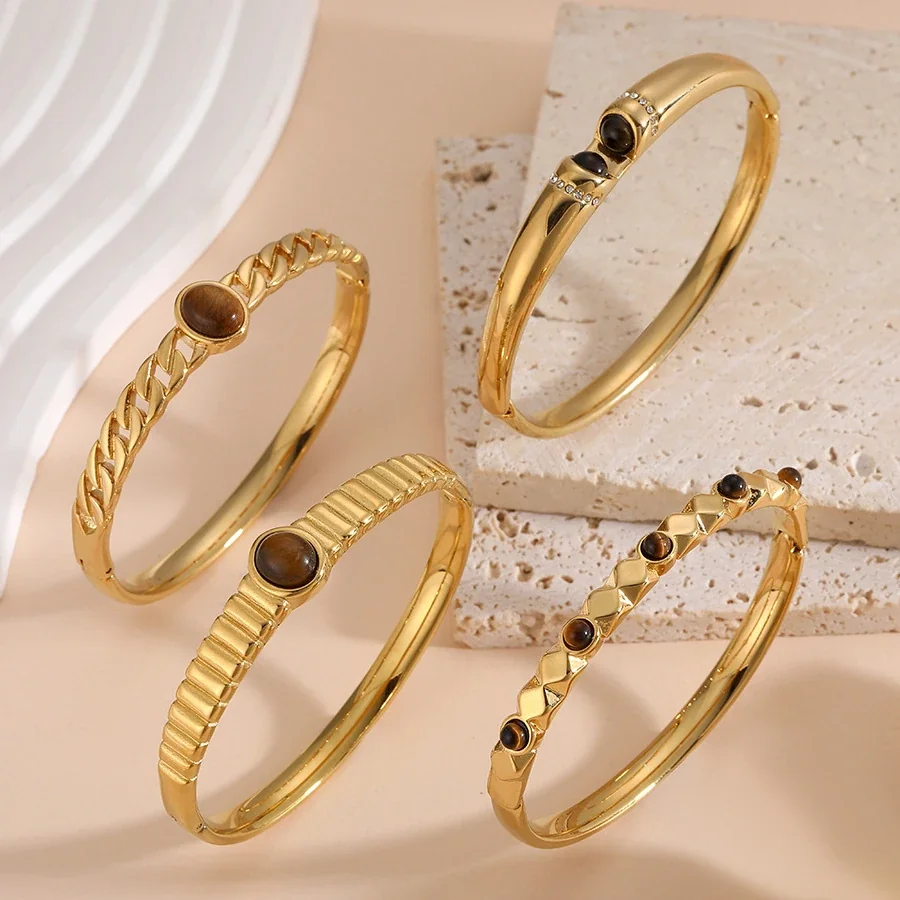 Foto del producto: Brazalete rígido con cristal ovalado marrón y acero chapado en oro