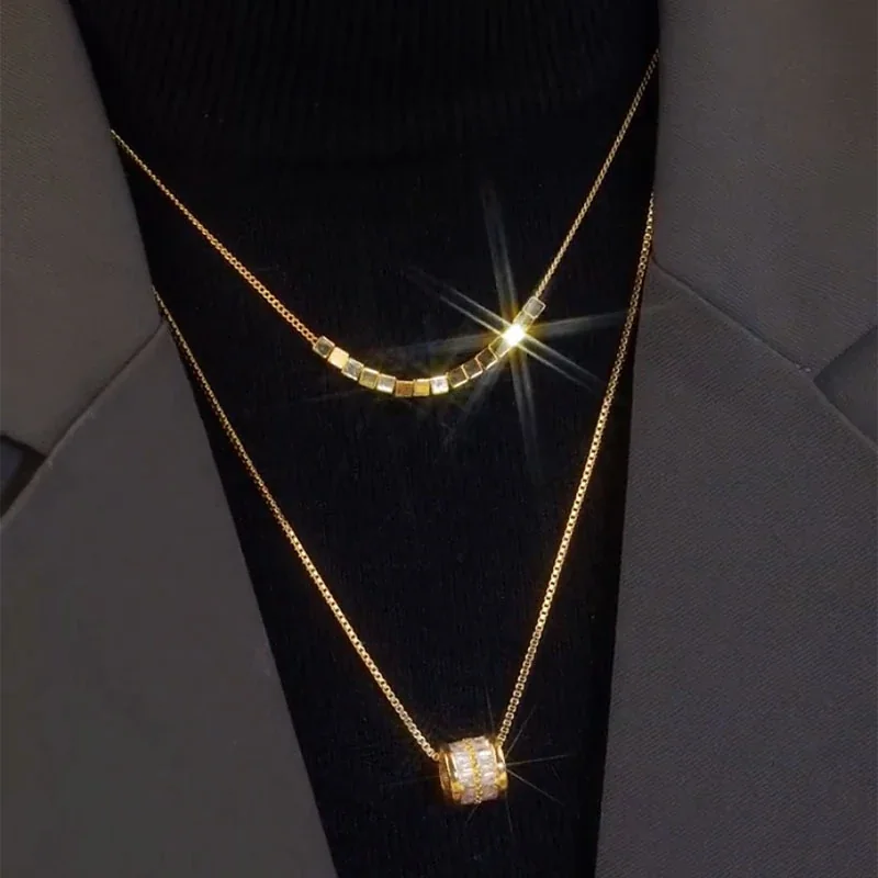Gelaagde ketting met kubuskralen en cilindervormige hanger, verguld roestvrij staal productfoto