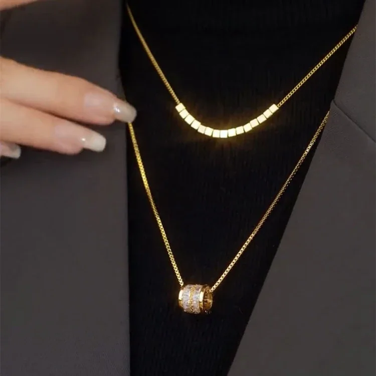 Gelaagde ketting met kubuskralen en cilindervormige hanger, verguld roestvrij staal productfoto