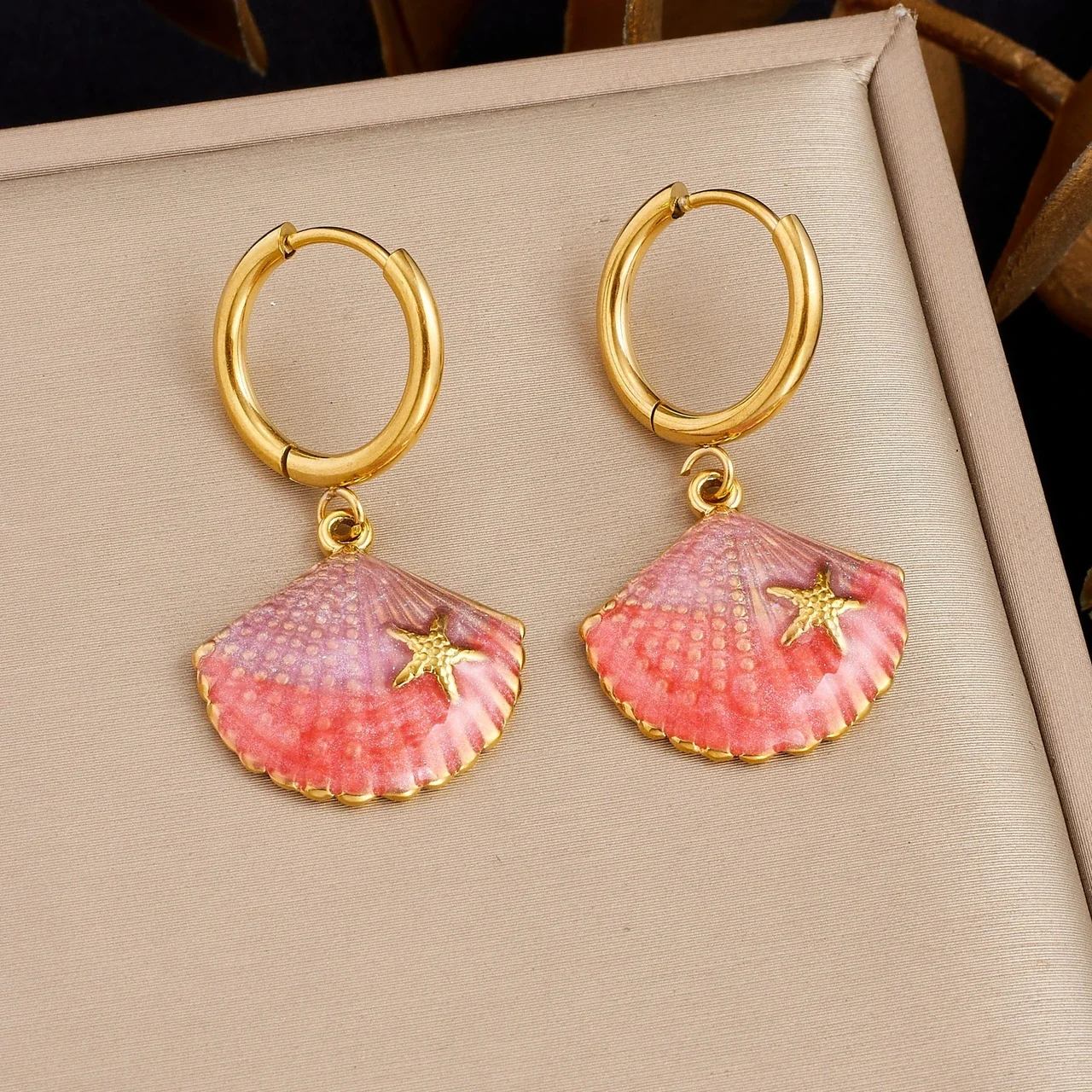 Druppelvormige oorringen met roze schelp en zeester, verguld staal productfoto