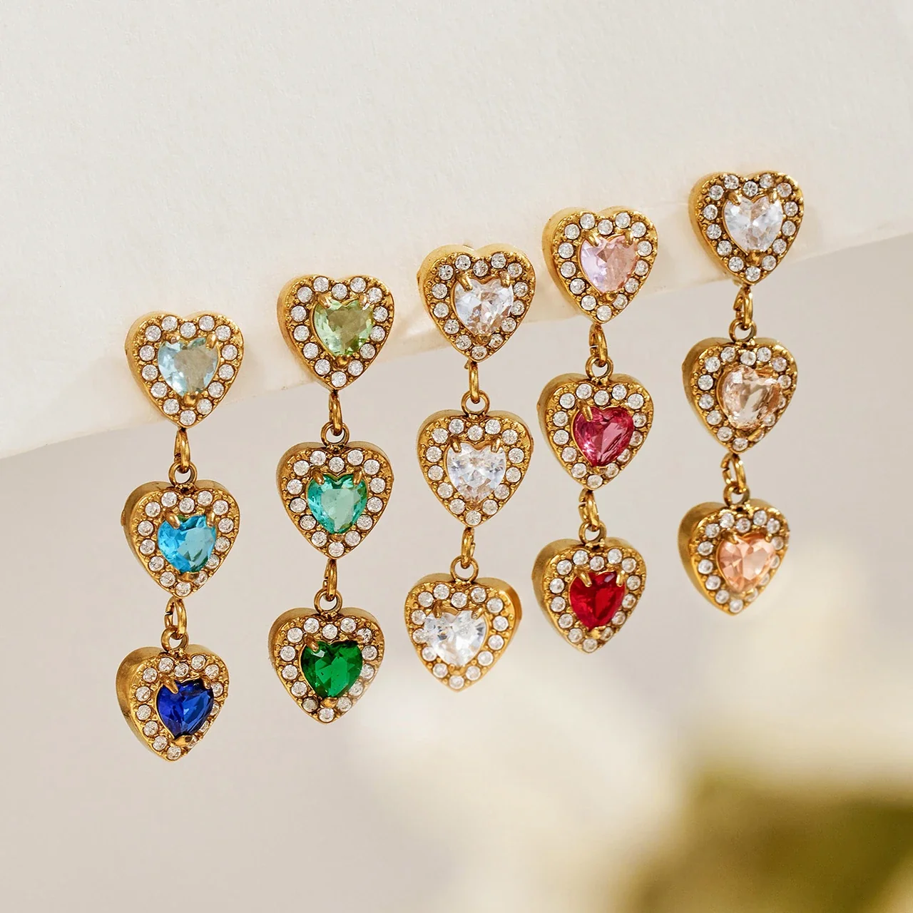 Oorhangers met drie CZ-harten met halo, verguld roestvrij staal productfoto