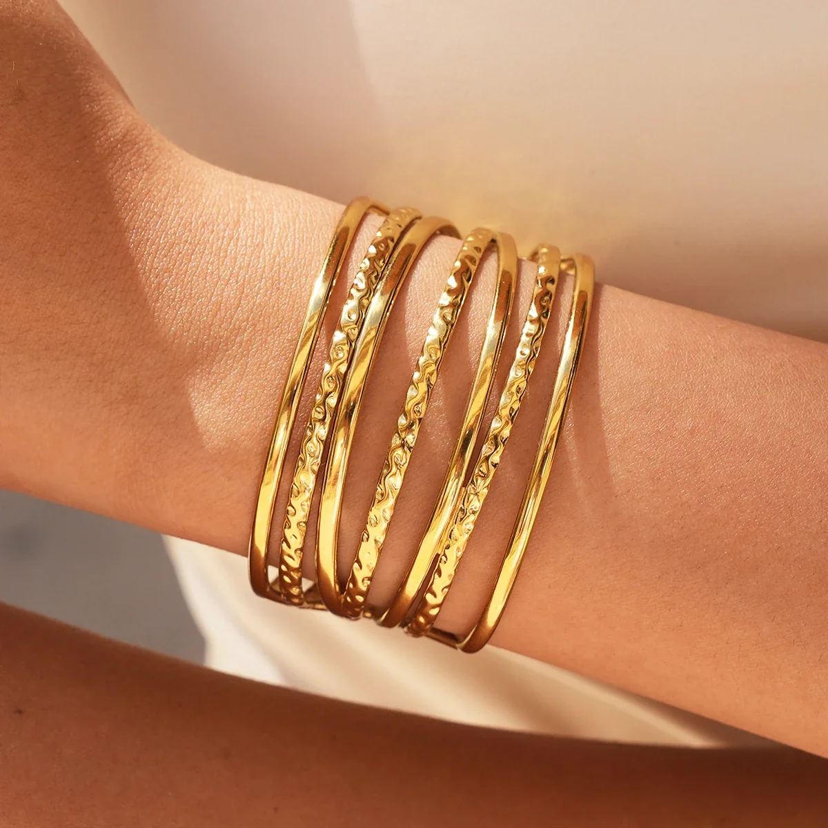 Open cuffarmband met gehamerde banden in 18K goud PVD productfoto