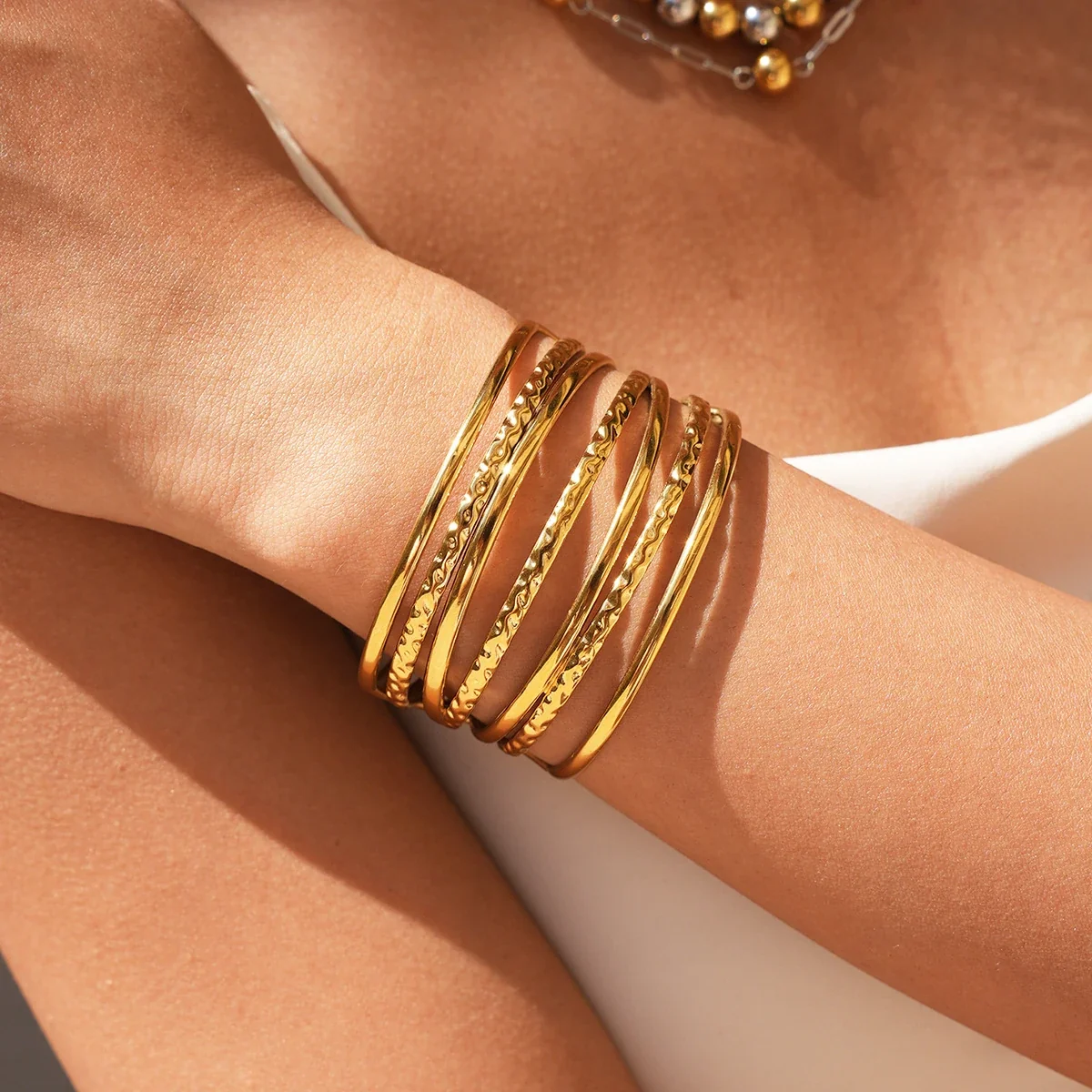 Open cuffarmband met gehamerde banden in 18K goud PVD productfoto