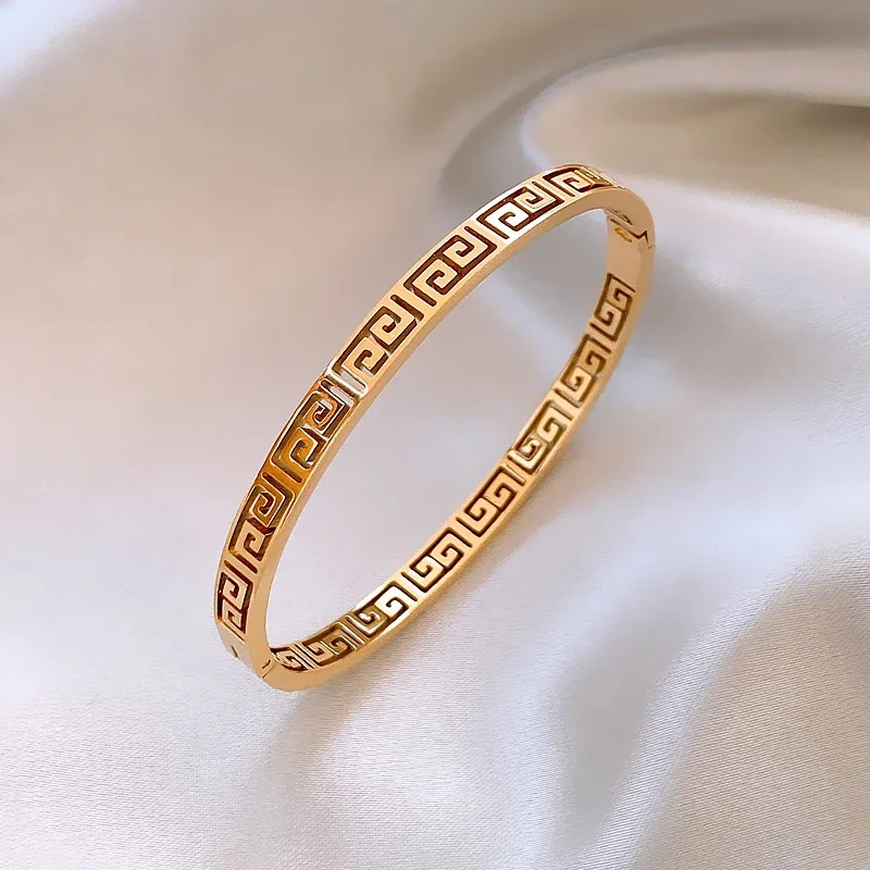 Bangle met Grieks sleutelmotief en uitsparingen, verguld roestvrij staal productfoto