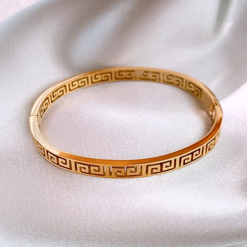 Bangle met Grieks sleutelmotief en uitsparingen, verguld roestvrij staal productfoto