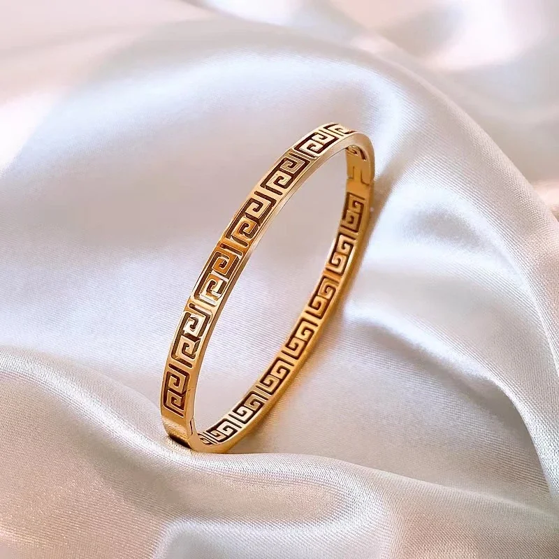 Bangle met Grieks sleutelmotief en uitsparingen, verguld roestvrij staal productfoto