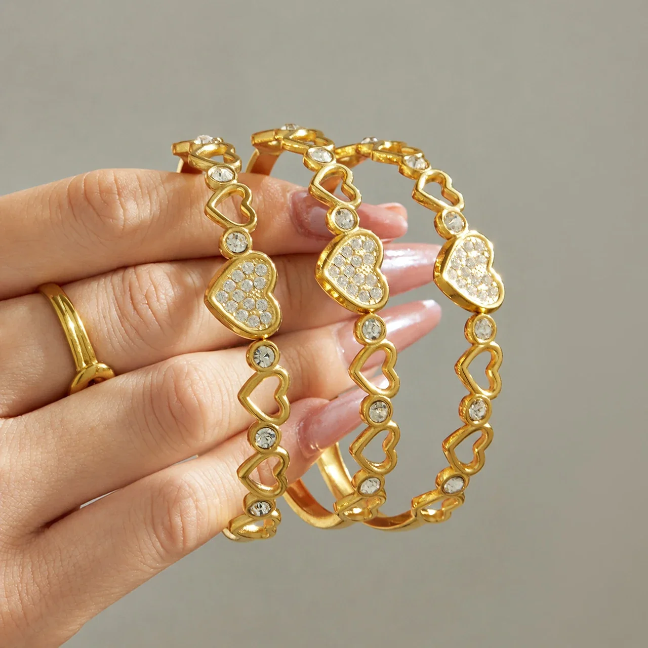 Foto prodotto: Bracciale rigido con maglie a cuore e zirconia cubica in acciaio inox 316 color oro