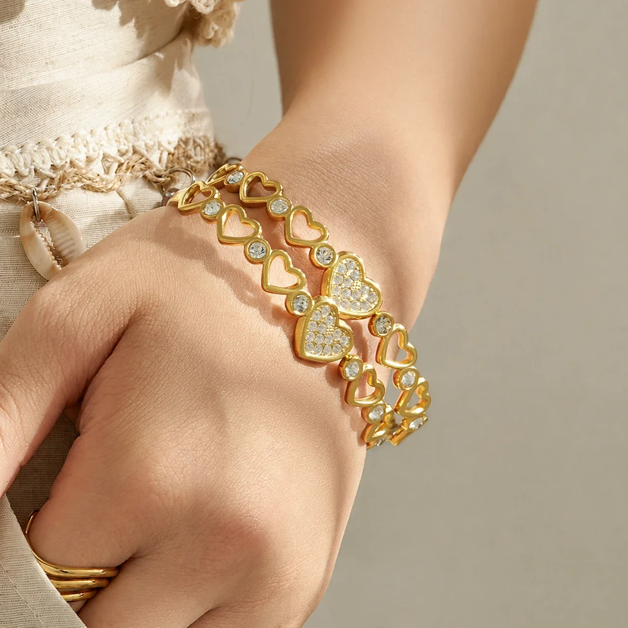 Foto prodotto: Bracciale rigido con maglie a cuore e zirconia cubica in acciaio inox 316 color oro