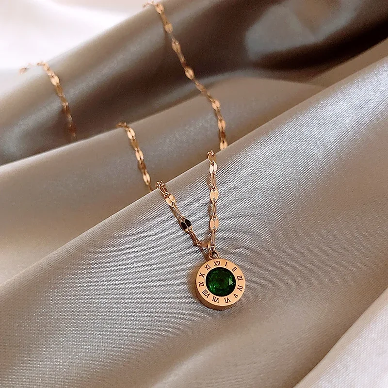 Foto del producto: Collar: acero inoxidable tono dorado con cristal verde y números romanos