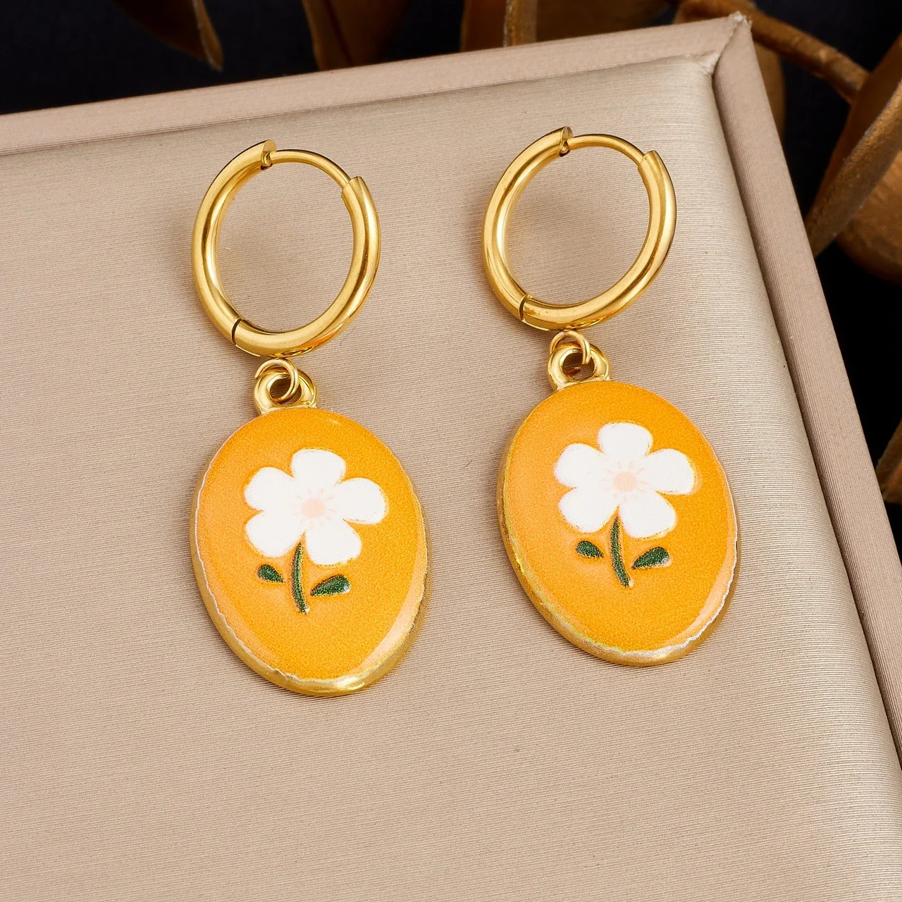 Oorringen met oranje geëmailleerde bloemhangers, goudkleurig productfoto